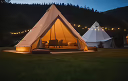 a lit tent with outdoor seating inside