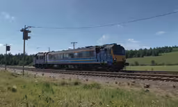 a train engine and some cars traveling on a track,an amtrak train in the country going through rural area
