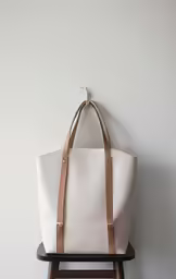 a white tote bag hanging on a wall