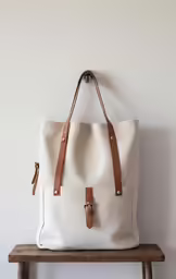 the white bag sitting on top of a wooden bench