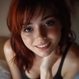 woman sitting on a bed smiling with her hands on the head
