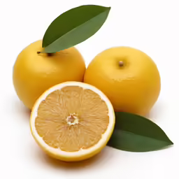 a yellow lemon with some leaves on it and the halves of one