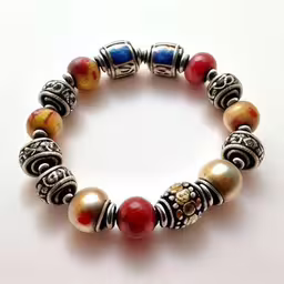 an assortment of colorful beaded items on a white surface,the bracelet is made up of various beads