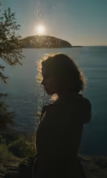 the young woman stands near a cliff by the ocean