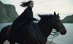 a beautiful woman riding on the back of a brown horse