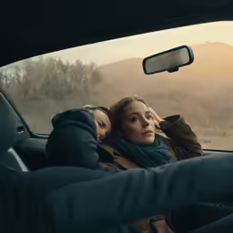 two women are looking out the back window