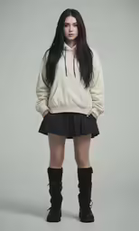 a woman with long hair wearing black boots and an oversize sweatshirt