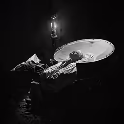 the man lies down in a large, round bathtub