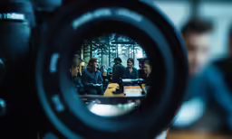 people are talking outside with a camera in front of them