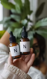 two small bottles with n and no on them in front of a plant