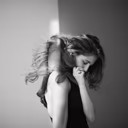 a girl in black dress holding her hair