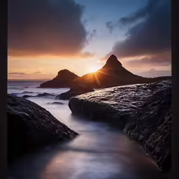 the sun is going down behind two large rocks
