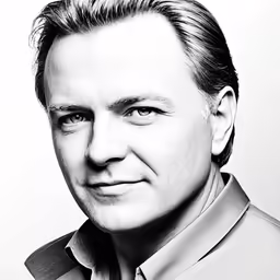 a black and white photo of a man smiling