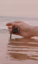 someone holding a small camera in the water