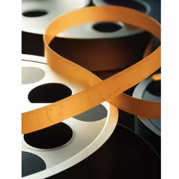 a pair of orange plastic rulers next to a film strip
