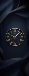 a golden clock on a black surface with an intricate background