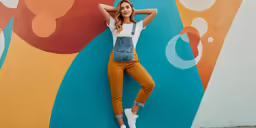 a beautiful young woman standing in front of a mural