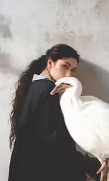 a young woman is posing with a white bird