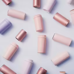 several different types of pink lipstick sitting on top of a table