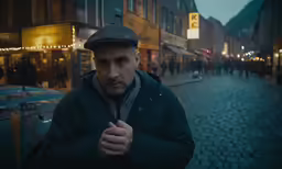 a man holding something in his hands on the street