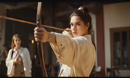the women are playing archery with each other