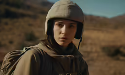 a woman wearing a helmet and walking away from the camera