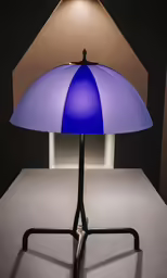 a lamp made of different shades of blue sitting on a stand
