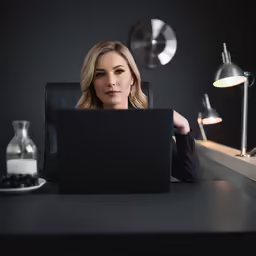 a woman is using a laptop computer at the desk