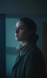 a woman is looking out the window and has blue eyes