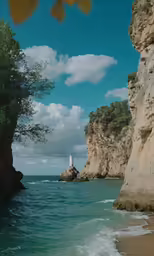 a man stands on the edge of a cliff looking out at the ocean
