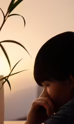 a little kid with a phone and a plant