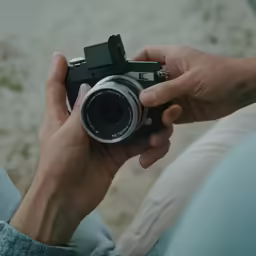 a man is holding an old fashioned camera