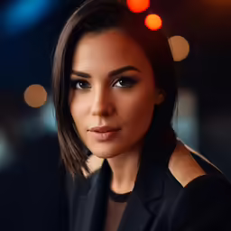 a woman in a black jacket looking at the camera