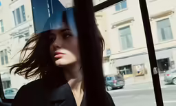 the woman is driving down the street near a bus