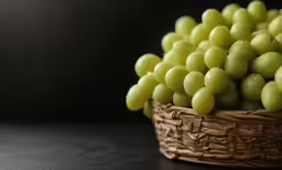 a basket full of green grapes on a table