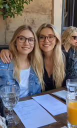 a couple of beautiful blonde girls sitting next to each other