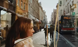 the woman looks at the bus and the street where they are walking