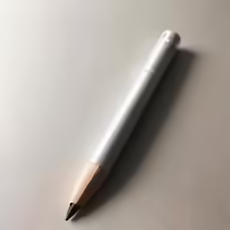 a wooden pen with a black tip resting on a surface
