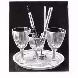 three different glasses on a white plate with silverware
