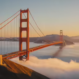 the golden gate bridge is in thick fog above the water