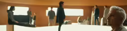a white haired male wearing a black blazer in a meeting room