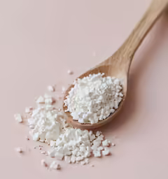 a spoon with sugar and pieces of white stuff