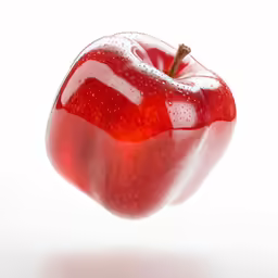 an apple is in the air with water droplets on it