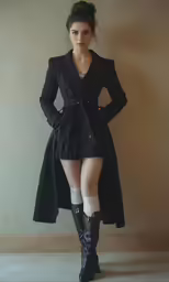 a woman wearing tight black boots and an over - coat