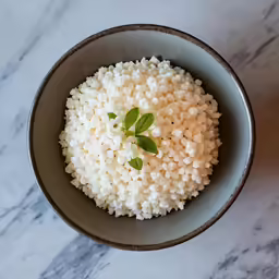 bowl with rice, with leaf, sitting on a marble surface