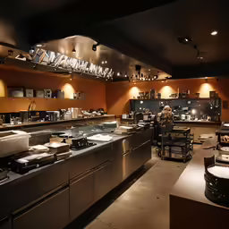 an open kitchen with several tables and some sinks