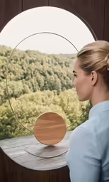 woman staring through circular window at scenery