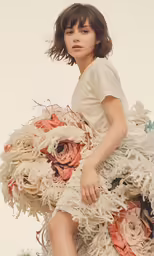 a woman sitting on top of an arrangement of paper