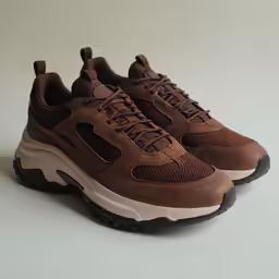the brown sneaker sneakers are on a white surface