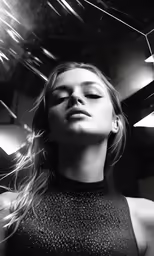 a woman in black and white photo with some lights behind her